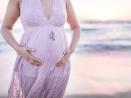 Photo of an elegant pregnant belly at sunset